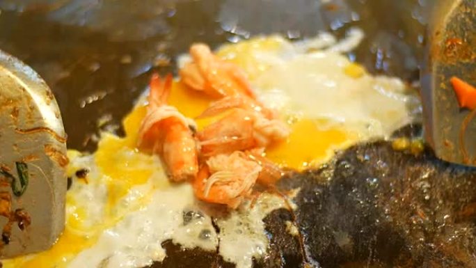 在煎锅中用鸡蛋和海鲜准备泰国面条。夜市，芭堤雅，Jomtien。泰国菜。市场上的亚洲异国菜肴