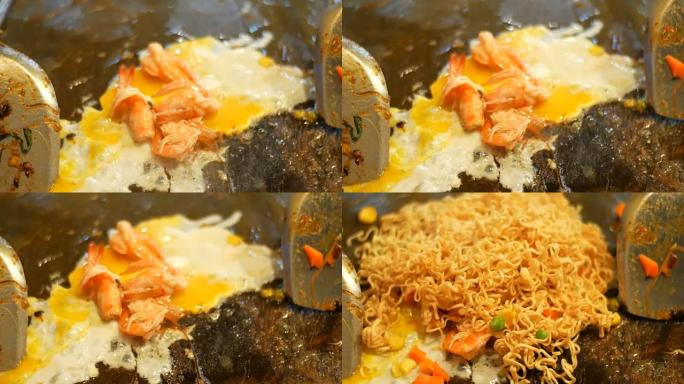 在煎锅中用鸡蛋和海鲜准备泰国面条。夜市，芭堤雅，Jomtien。泰国菜。市场上的亚洲异国菜肴