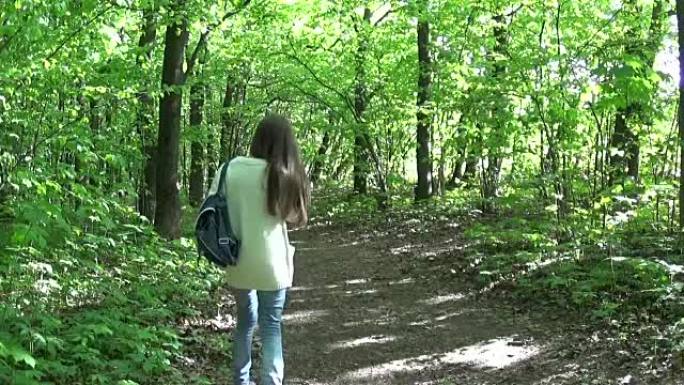 年轻迷人的女孩在公园散步时用电话说话。高清视频镜头全景与steadicam