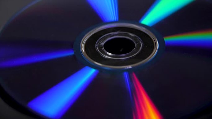 光盘隔离在黑色背景上。光盘上彩色彩虹反射的抽象宏观特写。丰富多彩的抽象背景。CD上的彩虹