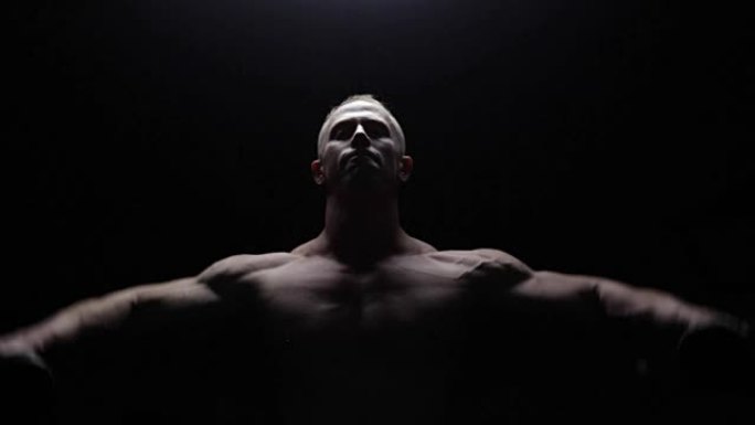 Shirtless bodybuilder workout in dark