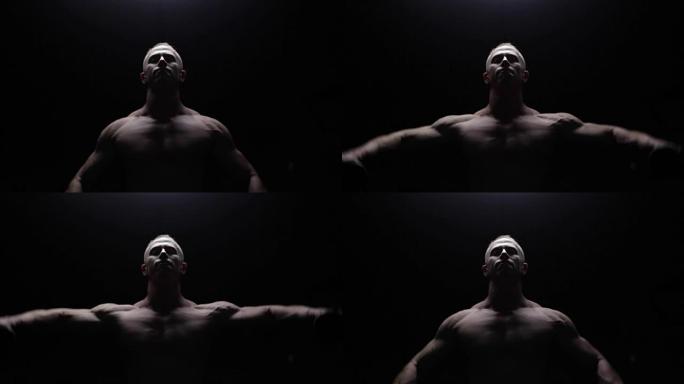 Shirtless bodybuilder workout in dark