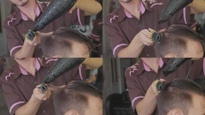 理发师在理发店为男性顾客制作梳子和吹风机发型。