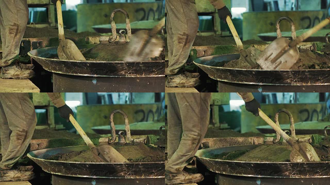 铲子工人在金属大锅盖上晃动水泥颗粒