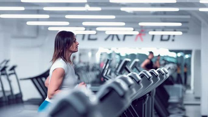 Adult woman runs on treadmill at the fitness centr