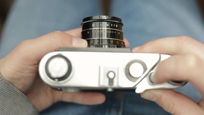 摄影师之手使用老式的苏联电影相机，对焦并拍照