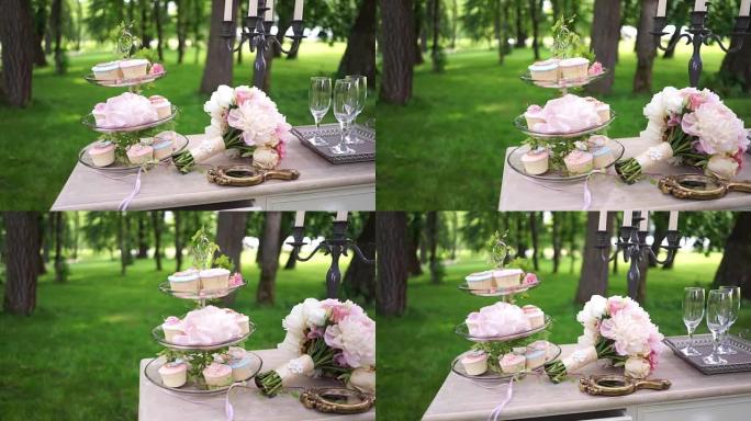 美丽的纸杯蛋糕放在玻璃架子上，躺在婚礼花束上