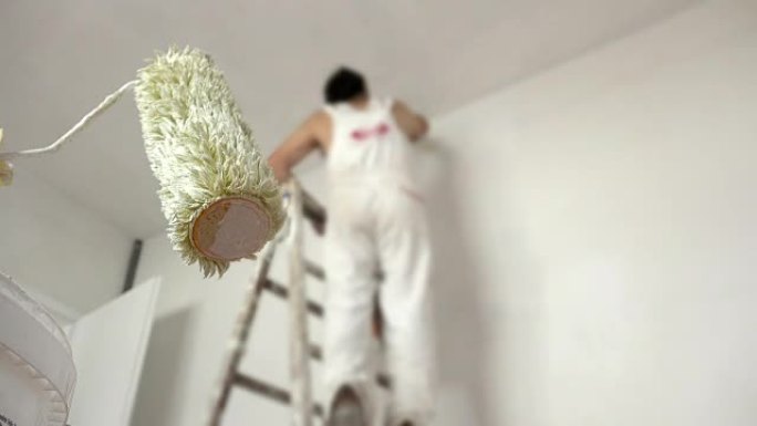 男人画墙，专注于油漆滚筒前景