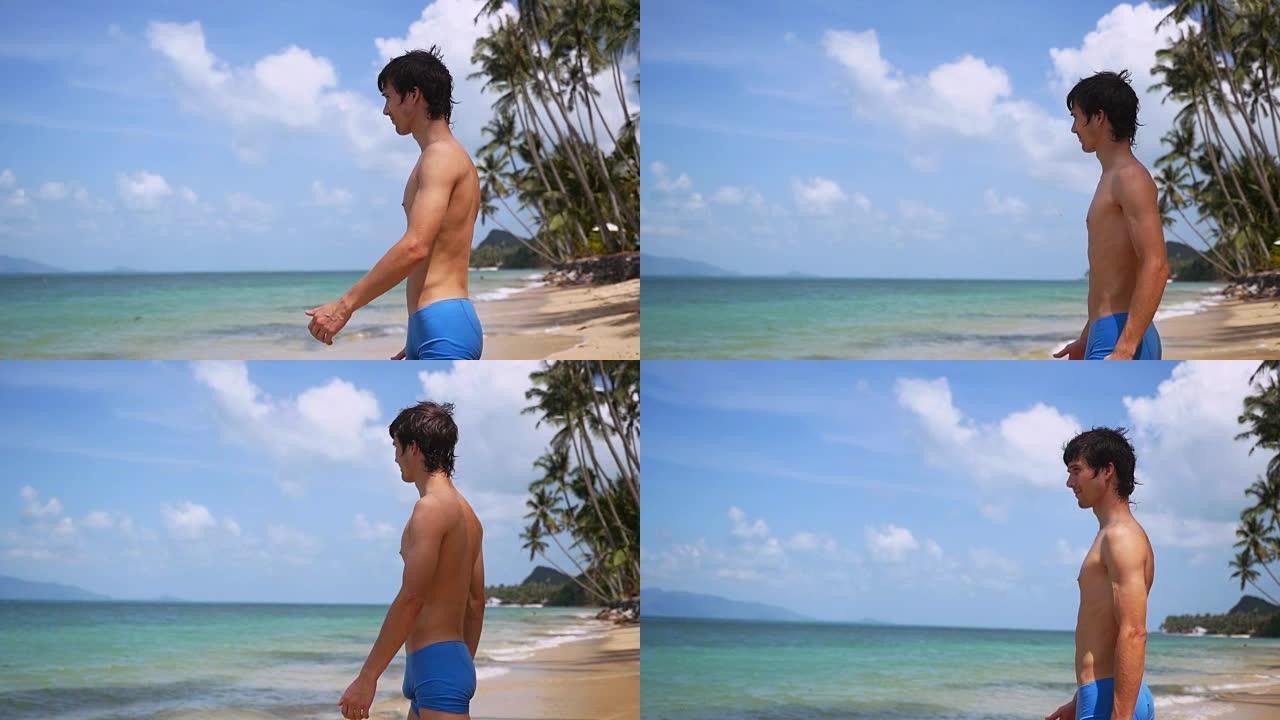 年轻英俊的男子走在热带海滩上享受他的假期阳光明媚的一天。缓慢的运动。1920 x1080
