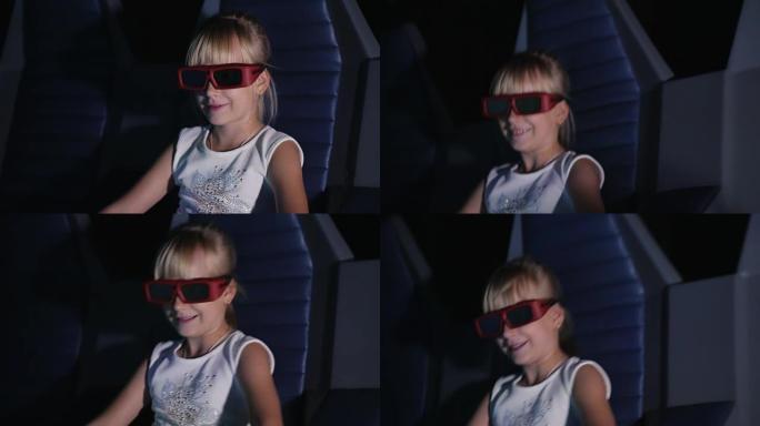 戴眼镜的酷金发女孩在电影院看电影。它吹着风，动感的椅子