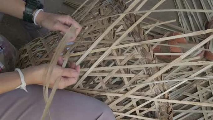 女性双手手工编织竹篮。女人制作手工柳条篮