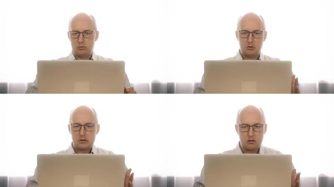 戴着眼镜的愤怒的商人很担心笔记本电脑突然出现故障。强调这个人有笔记本电脑的问题。