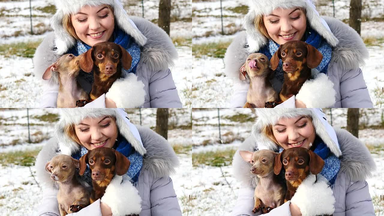 女人在冬天外面和她的小狗玩耍