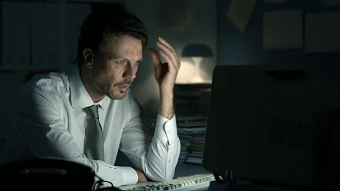 疲倦沮丧的业务主管在办公室深夜工作，他凝视着计算机屏幕并收到错误消息
