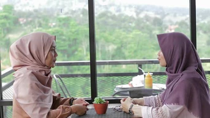 两名美丽的穆斯林妇女在咖啡馆聚会，经过编辑和原始