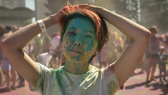 年轻快乐的亚洲女孩在夏季白天的洒红节上玩彩色粉末的头发，颜色概念