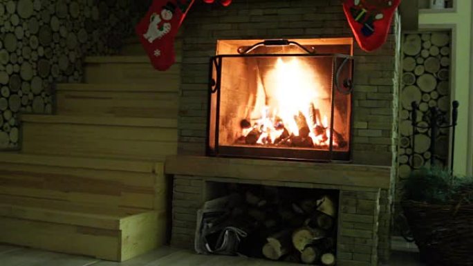 带有圣诞装饰品的壁炉。木柴在壁炉里燃烧