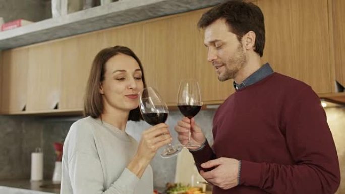 微笑的夫妇在厨房喝红酒