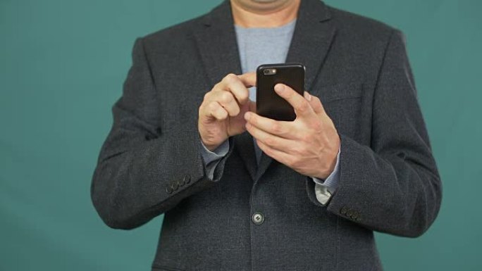 成年男子使用屏幕智能手机浏览绿色背景上的网站