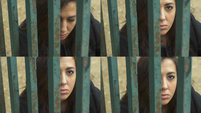笼子后面悲伤沮丧的女人。关系的囚徒
