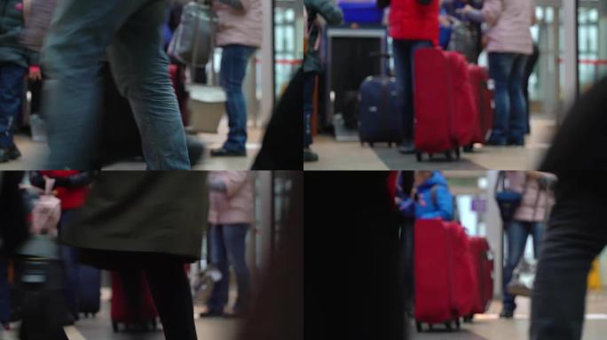 机场安检入口行李控制。扫描行李。一个男孩和一个大的红色行李箱的家庭通过入口控制装置，将行李装载到手推