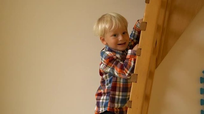 幼儿园里的小男孩爬梯