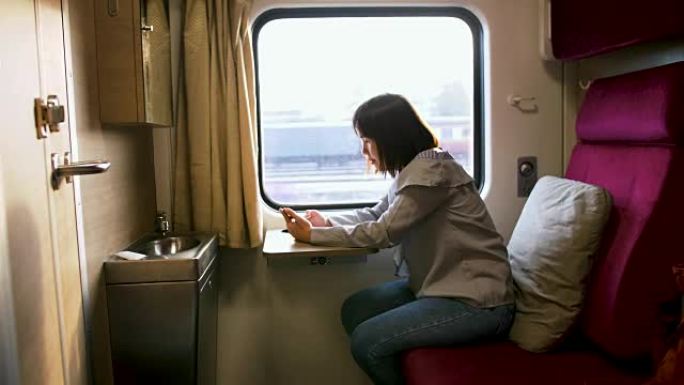 乘火车旅行时使用智能手机的美女