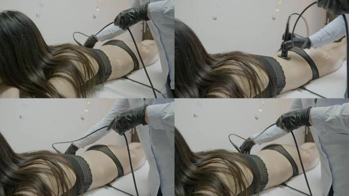美容院躺在床上的女人，通过美容师使用超声波空化人体轮廓仪进行脂肪按摩和造型身体