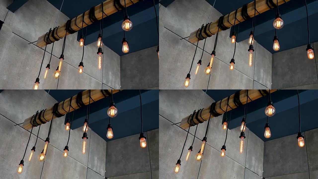 燃烧的爱迪生灯泡不同的形状挂在房间的横梁上