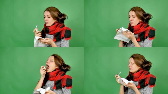 一个患有流感的迷人黑发女人的肖像。这个女孩感冒了，发热了，脖子上裹着围巾。她用喷雾剂喷喉咙。心绞痛，