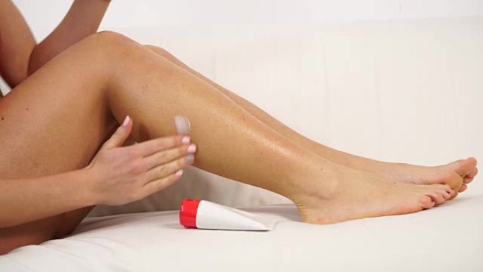 女人在受伤疼痛小腿4K上涂上药膏