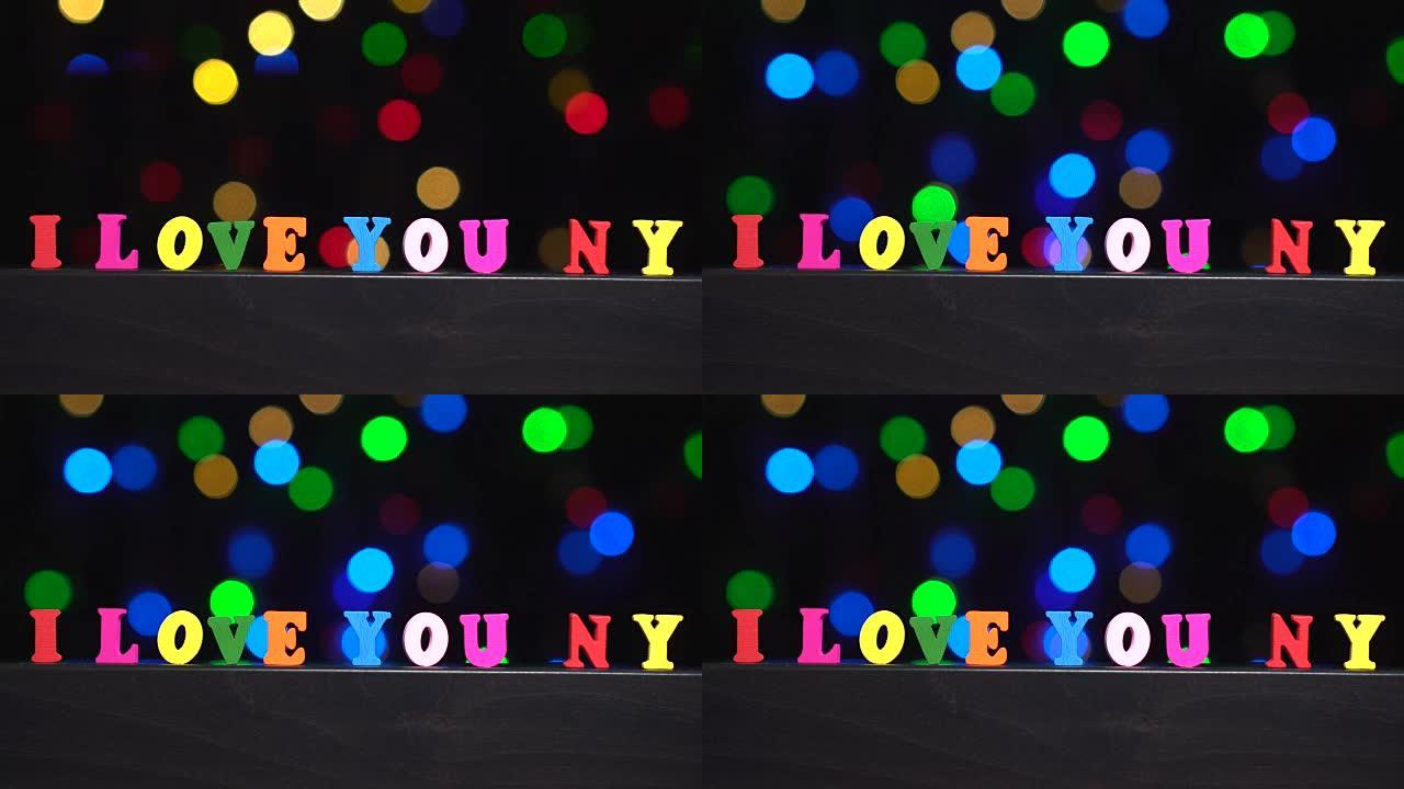 彩色单词 “i love you NY” 来自抽象模糊灯光前的多色木制字母bokeh背景