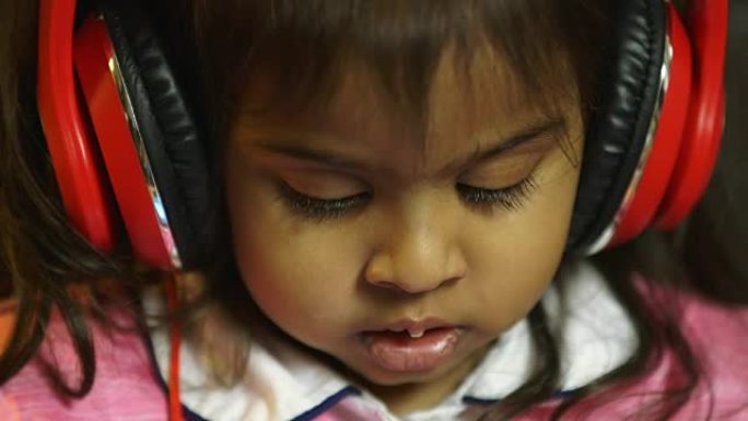 一个戴着大耳机的印度小孩的特写镜头。
