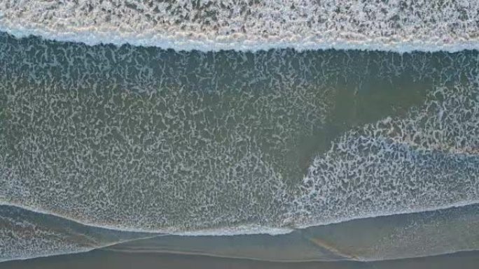 偷听海浪在岸上坠毁的空中无人机镜头