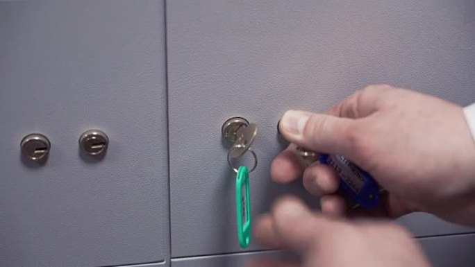 两个人用两把钥匙将保险箱锁上