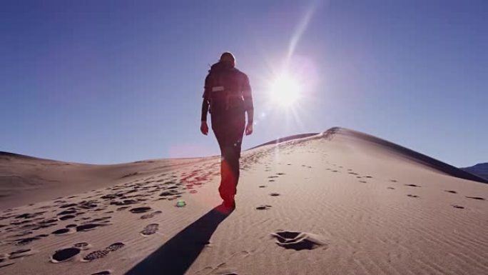 女性高加索徒步旅行者穿越沙漠沙丘