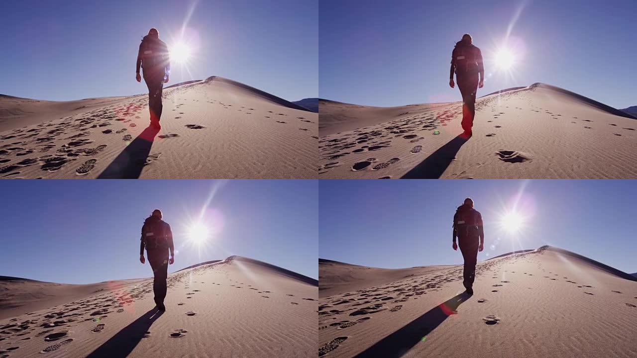 女性高加索徒步旅行者穿越沙漠沙丘