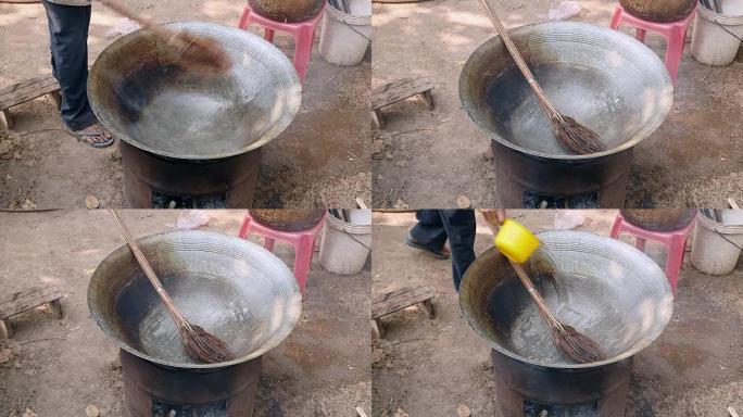 close up of a man washing a hot wok cooking with a