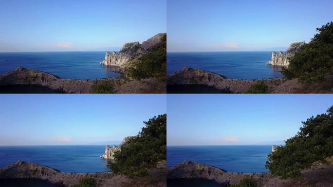 鸟瞰图: 通过克里米亚的岩石看到大海的早晨。4k卡普奇克角蓝湾的美丽景色