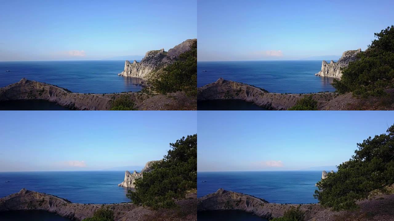 鸟瞰图: 通过克里米亚的岩石看到大海的早晨。4k卡普奇克角蓝湾的美丽景色