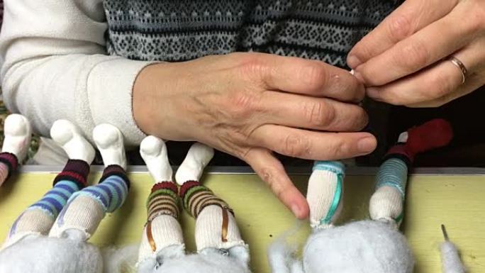 木偶大师为洋娃娃制作鞋子和衣服。