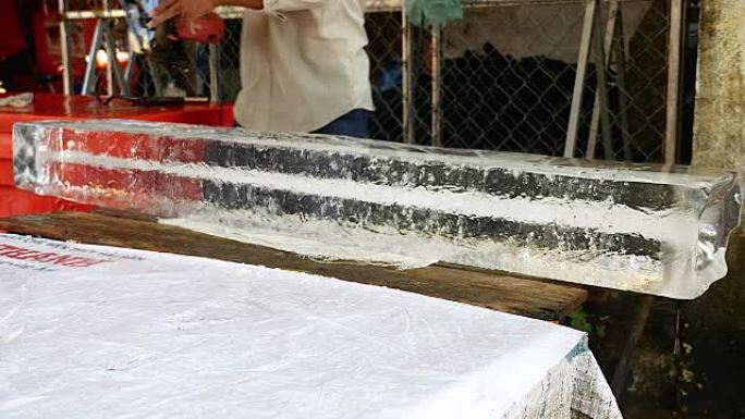 冰卖家用圆锯从较大的冰块中预切小块冰块