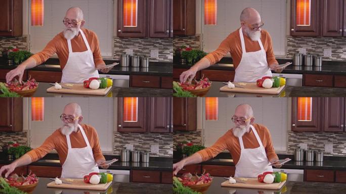 老厨师在使用平板电脑时伸手去拿些蔬菜