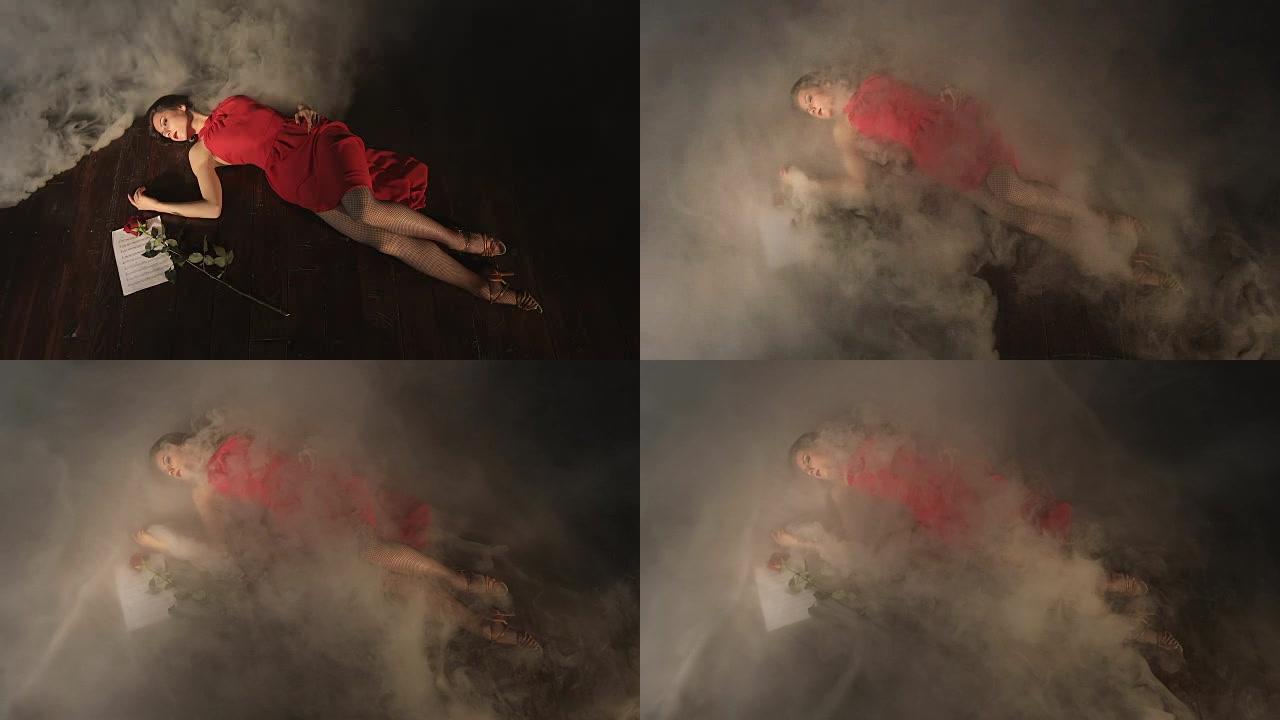一个穿着红色连衣裙的苗条年轻女子在表演探戈后躺在烟雾中。