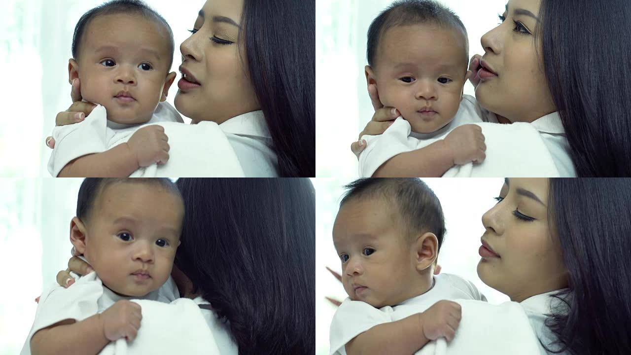 年轻美丽的亚洲妈妈关心和玩她的宝宝