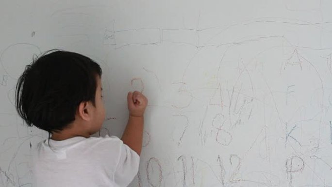 小男孩在墙壁背景上写作
