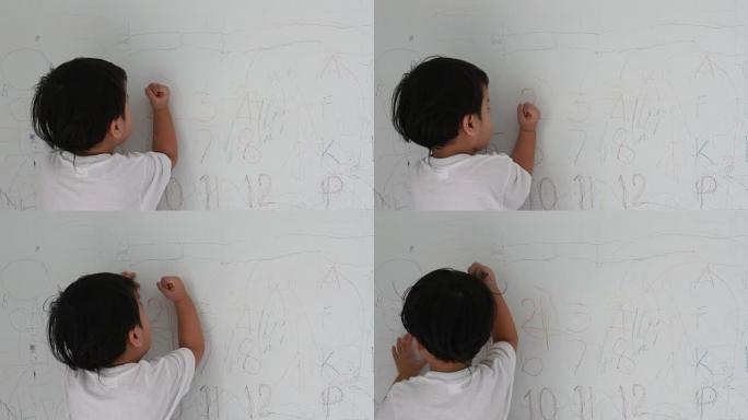 小男孩在墙壁背景上写作