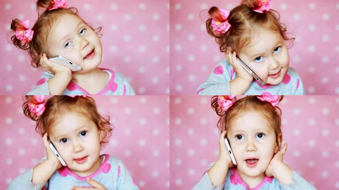 漂亮可爱的小女孩用手机打电话和聊天。一个有趣的孩子在智能手机上讲话，特写肖像