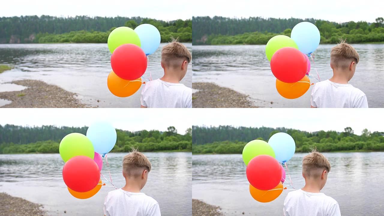 一个少年拿着气球。湖边大自然的暑假。庆祝和乐趣。孩子的生日