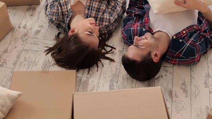 幸福的夫妇躺在新公寓的地板上